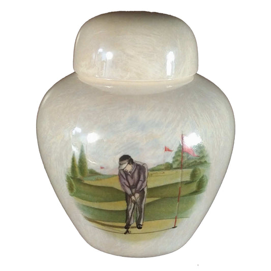 A beautiful keepsake cremation ceramic keepsake urn with a decoration of a golfer wearing a grey suit putting on a golf green with a mother-of-pearl finish.