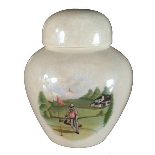 A beautiful keepsake cremation ceramic keepsake urn with a decoration of a golfer walking onto a green carrying a golf bag with a mother-of-pearl finish.
