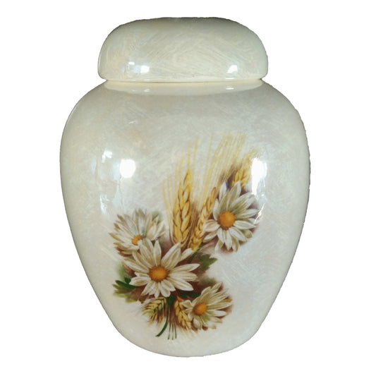 A beautiful medium sized cremation ceramic keepsake urn with a decoration of daisies and wheat with a mother-of-pearl luster finish.